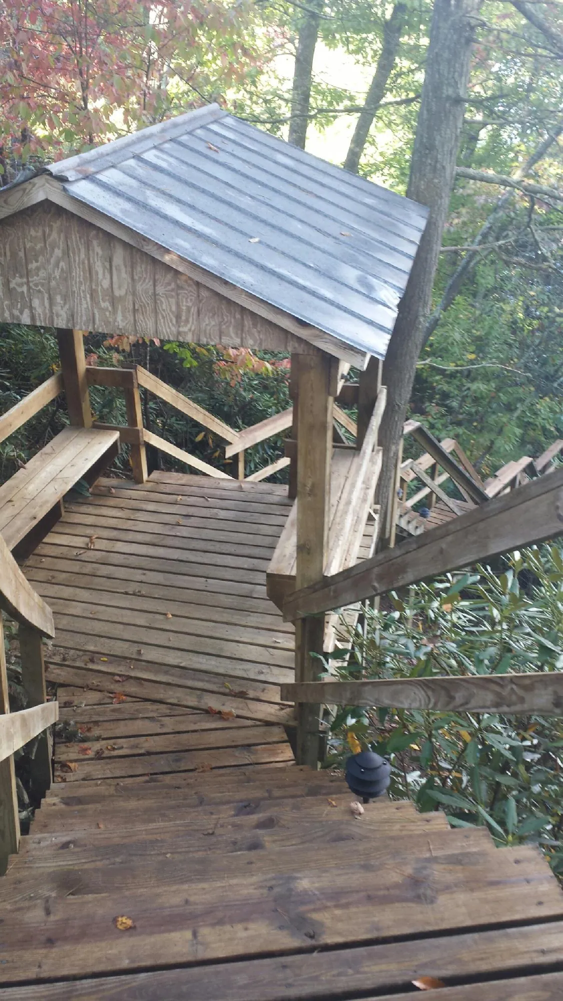 Metal roofed shelter over wooden steps on a wooded walkway — Skylight Repair & Installation work by our crew in Charlotte